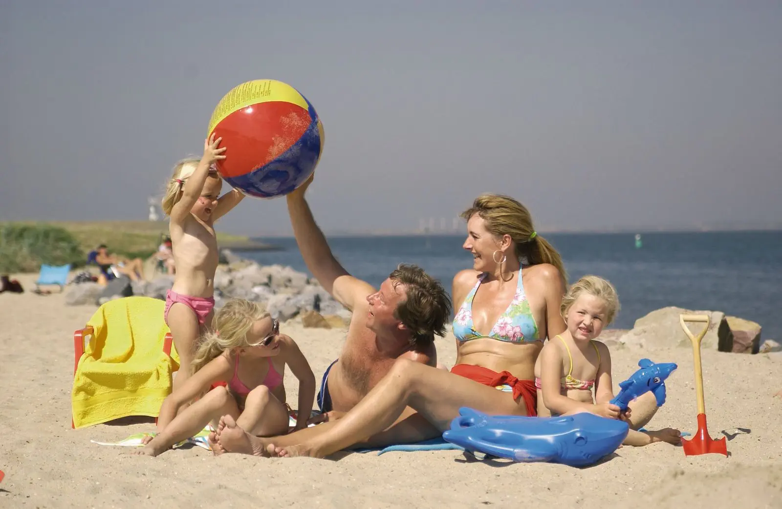 Gezin met kinderen speelt op het strand tijdens vakantie aan zee.